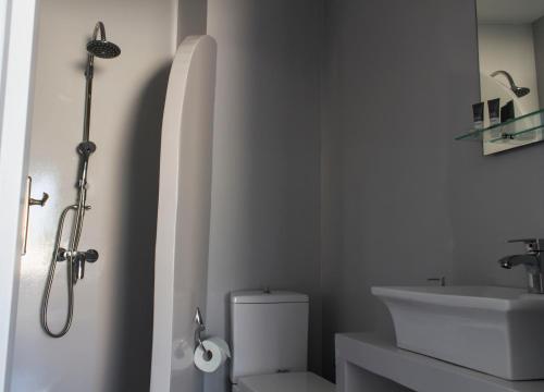 a bathroom with a shower and a toilet and a sink at Edem Rooms in Fira