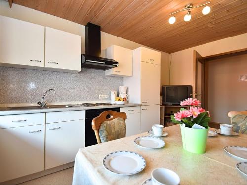a kitchen with a table with plates on it at Charming holiday flat in the Bavarian Forest in Gleißenberg
