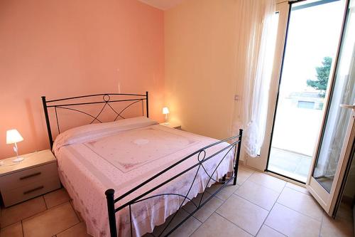 トッレ・パリにあるNuovo appartamento vacanzeのベッドルーム1室(ベッド1台、大きな窓付)