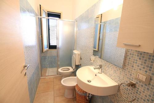 y baño con lavabo, aseo y ducha. en Nuovo appartamento vacanze, en Torre Pali