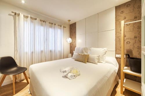 a bedroom with a white bed and a chair at Vientos de Marbella in Marbella