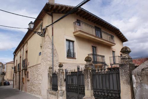 a building with a fence in front of it at Casa Rural El acebo in Prádena