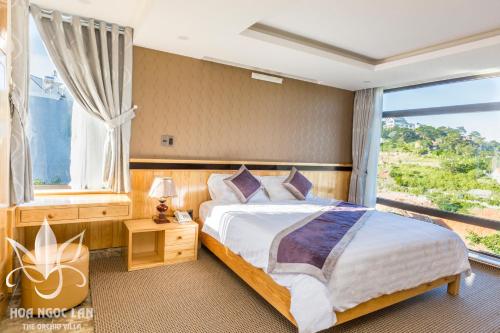 a bedroom with a large bed and a large window at The Orchid Villa Dalat in Da Lat