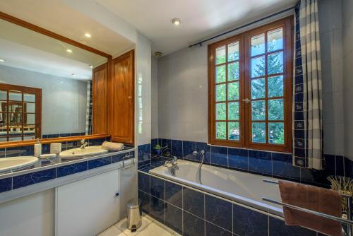 La salle de bains est pourvue d'une baignoire, d'un lavabo et d'un miroir. dans l'établissement Gîte Le Planier, à Saint-Priest