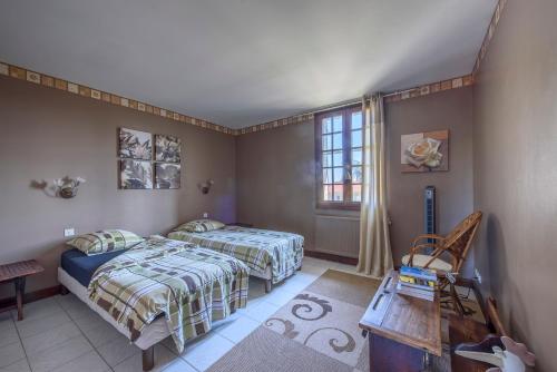 - une chambre avec 2 lits et une fenêtre dans l'établissement Gîte Le Planier, à Saint-Priest