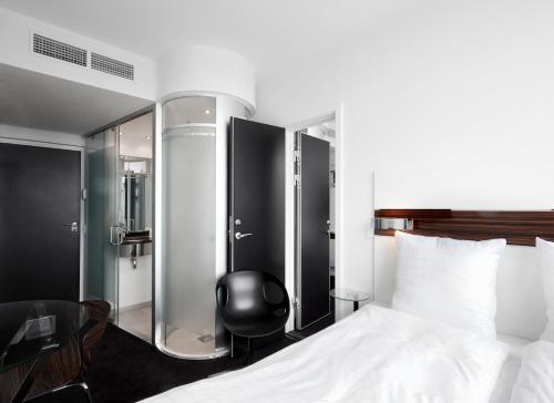 a hotel room with a bed and a chair at Wakeup - Aarhus in Aarhus