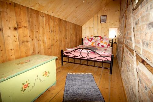 a room with a bed in a wooden cabin at Ferienhaus Anno Dazumal, wie zu Oma`s Zeiten in Klingenthal
