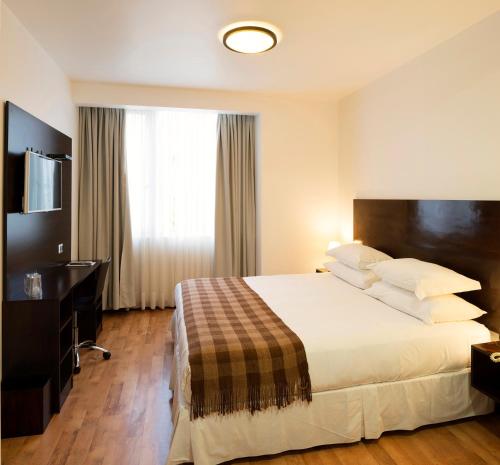 a hotel room with a bed and a television at Hotel Casa Beltran in Arica