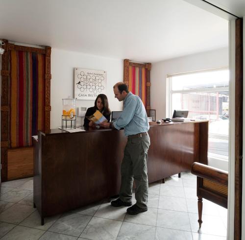 un hombre de pie en una recepción en una oficina en Hotel Casa Beltran, en Arica