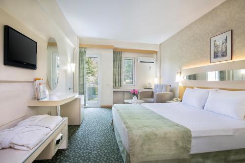 Habitación de hotel con cama grande y TV en Lycus River Thermal Hotel en Pamukkale