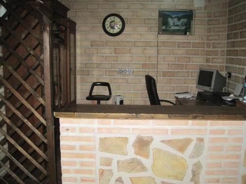 an office with a brick wall and a desk with a computer at Posada de los Cónsules in Consuegra