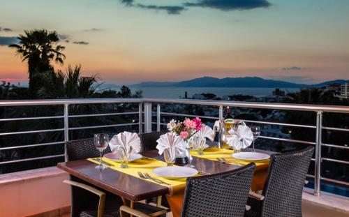 a table on a balcony with a view of the ocean at Palmin Hotel in Kusadası