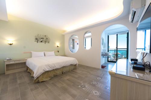 a bedroom with a large bed and a television at 看海民宿 in Eluan