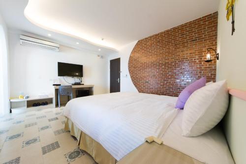 a bedroom with a large bed and a brick wall at 看海民宿 in Eluan