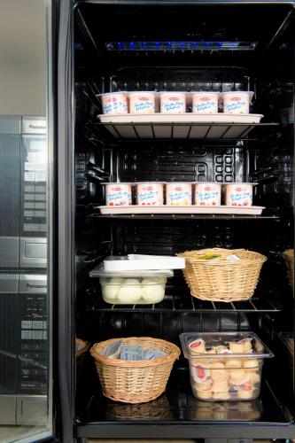 an open refrigerator with baskets of food in it at Hotel Brossard in Brossard