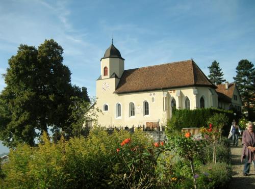 a church with a clock tower in a garden at Hotel Viktor in Viktorsberg