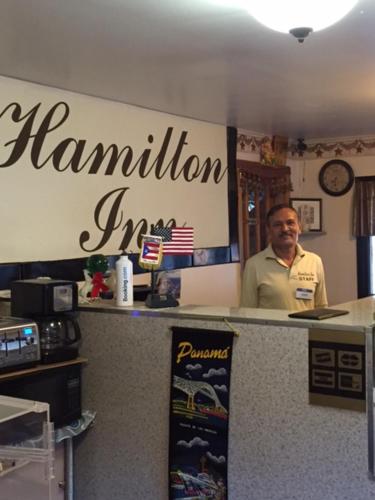 a man standing behind a counter in a restaurant at Hamilton Inn Sturbridge in Sturbridge