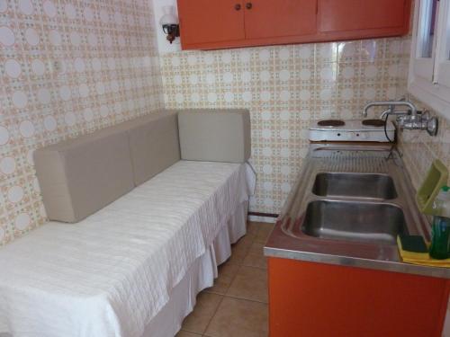 a small kitchen with a bed and a sink at Villa Niki in Serifos Chora