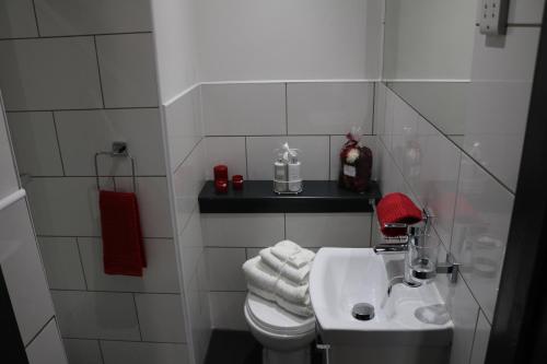 a white bathroom with a toilet and a sink at Trivelles Regency, Nottingham in Nottingham