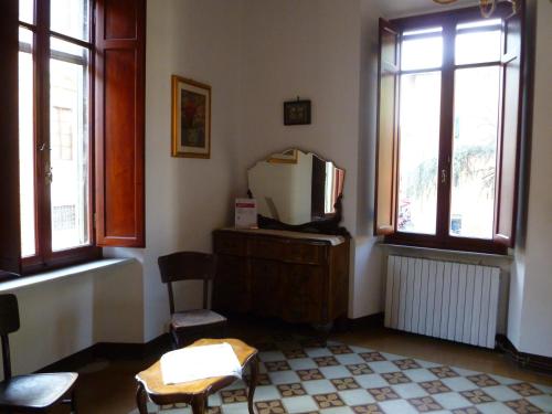 a living room with a tv and two chairs and windows at Time Out in Pisa