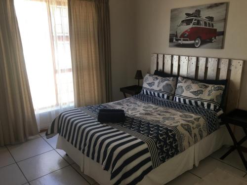 a bedroom with a bed with a black and white comforter at Jbay Tides in Jeffreys Bay