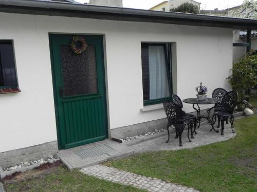 una puerta verde en una casa con mesa y sillas en Ferienzimmer Gleißner, en Ahlbeck