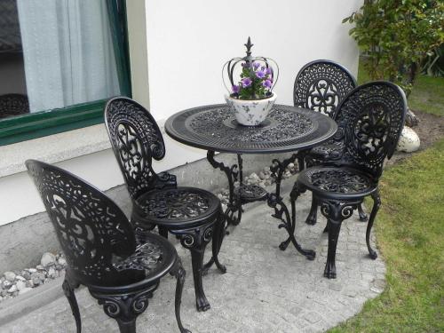 una mesa de patio y 4 sillas con un jarrón de flores en Ferienzimmer Gleißner, en Ahlbeck