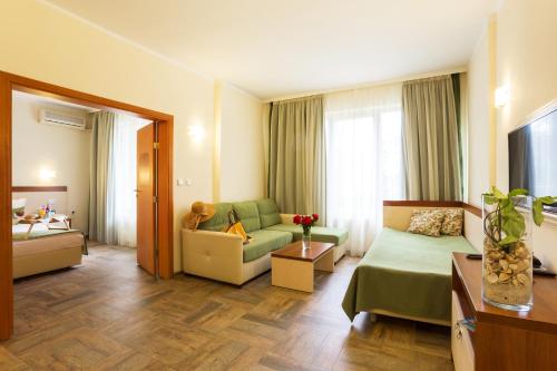 a hotel room with a couch and a living room at Ljuljak Hotel - Free Parking in Golden Sands