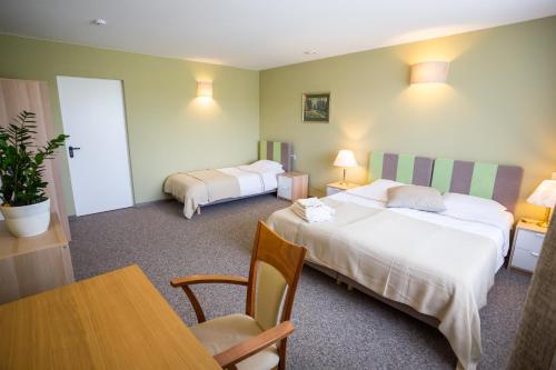 a hotel room with two beds and a table at Irbēni in Brivkalni