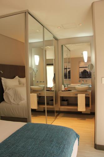 a bedroom with two sinks and a bed and mirrors at Hotel CityFlats in Bogotá