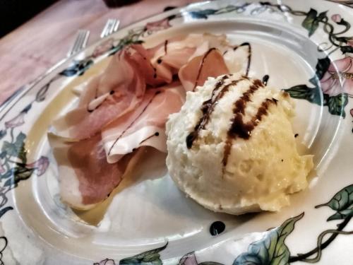 a plate of food with ham on a table at Hotel Al Caminetto in Valtournenche