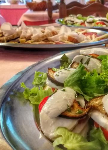 a plate of food with a salad on a table at Hotel Al Caminetto in Valtournenche