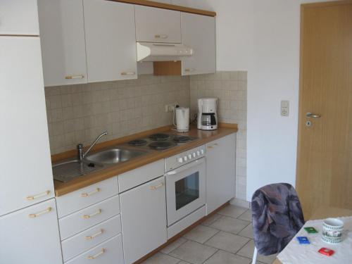 a kitchen with a sink and a stove top oven at Ferienwohnung Meyer in Schönwald