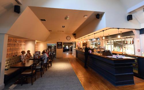 a bar in a restaurant with people sitting at tables at Olde House, Chesterfield by Marston's Inns in Chesterfield