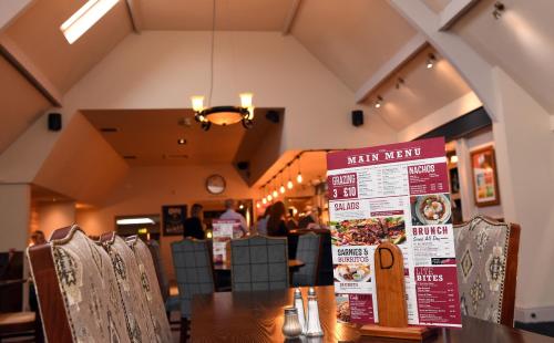 a restaurant with a table with a menu on it at Olde House, Chesterfield by Marston's Inns in Chesterfield