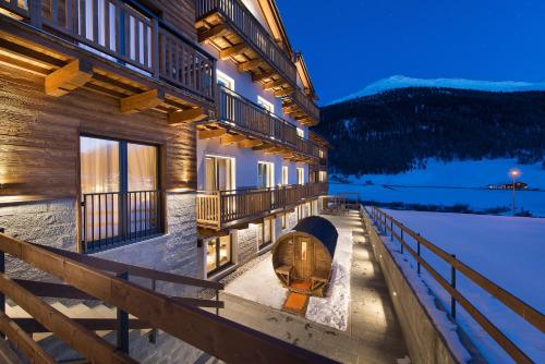 a building with a fire pit on the side of it at Hotel Sporting Family Hospitality in Livigno