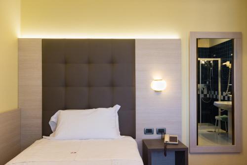 a bedroom with a bed with a large headboard and a mirror at Park Hotel Ristorante Ca' Bianca in Istrana