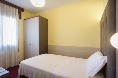 a bedroom with a white bed and a cabinet at Park Hotel Ristorante Ca' Bianca in Istrana