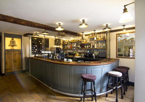 a bar with stools in a room with a counter at Church Inn in Ludlow