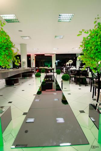 a dining hall with tables and chairs and plants at Hotel e Restaurante Bordignon in Joaçaba