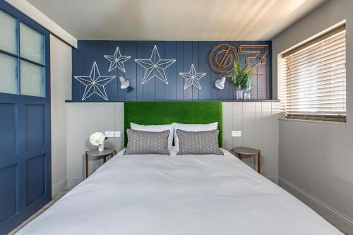 a bedroom with a large bed with a blue wall at Ffolkes Arms Hotel in Hillington