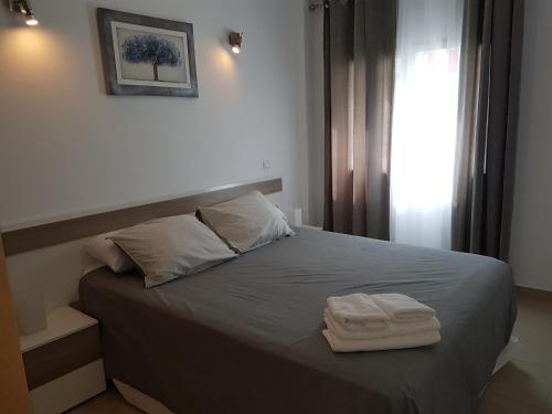 a bedroom with a bed with two towels on it at Apartamento en el centro de Nerja in Nerja