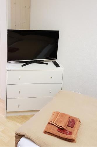 a white dresser with a tv on top of it at Hotel Löwen in Mellingen