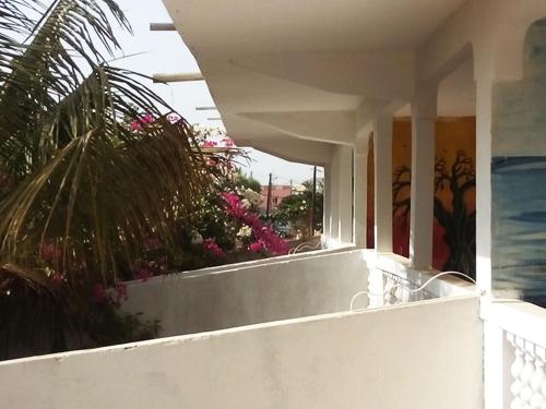 a balcony of a house with pink flowers at Guesthouse Dalal ak Jàmm in Mbour