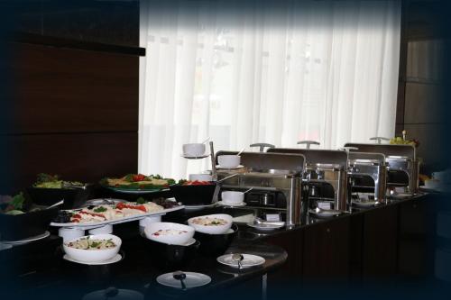 a buffet line with plates of food on a table at Orange Suites Hotel in Manama