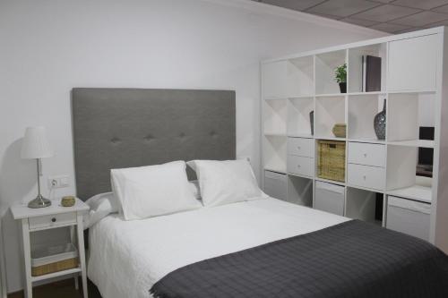 ein Schlafzimmer mit einem großen Bett mit weißen Regalen in der Unterkunft Apartamento María in Baena