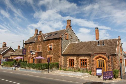 a large brick building on the side of a street at Ffolkes Arms Hotel in Hillington