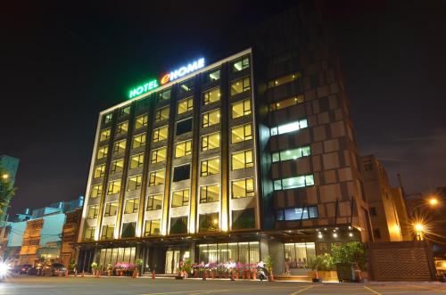 a building with a hotel sign on top of it at eHome Hotel in Taoyuan
