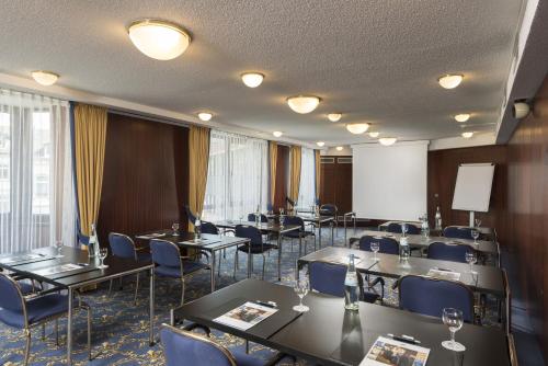 a conference room with tables and chairs and a whiteboard at Maritim Hotel Bad Homburg in Bad Homburg vor der Höhe