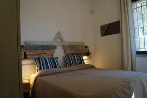 オロゼーイにあるSa Tanca de Mannoiのベッドルーム1室(木製ヘッドボード付きのベッド1台付)